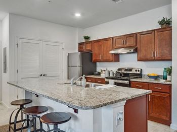 a kitchen with a granite counter top and wooden cabinets
